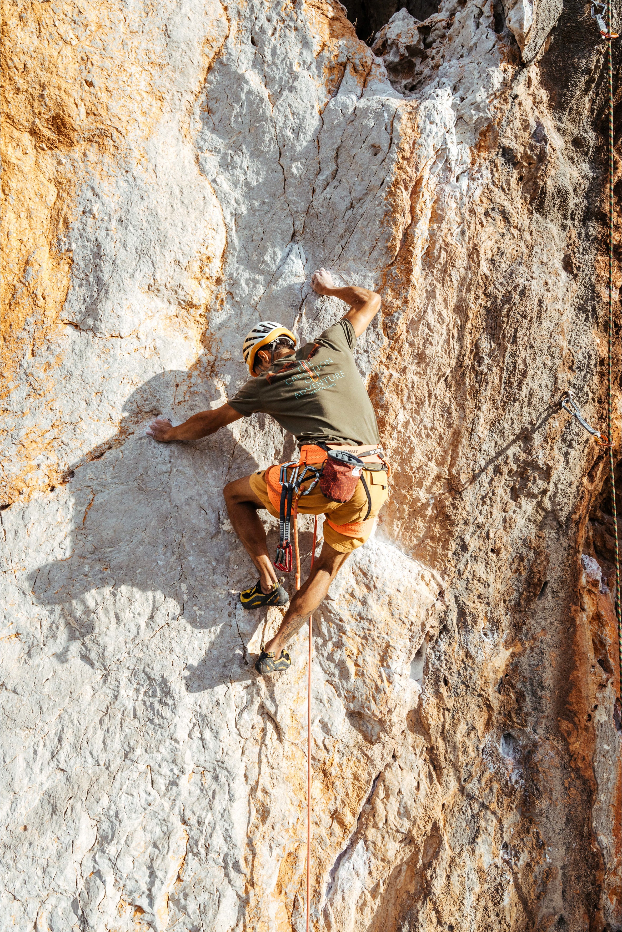 Person rock climbing with the green the creation of adventure t-shirt from vertical vibes